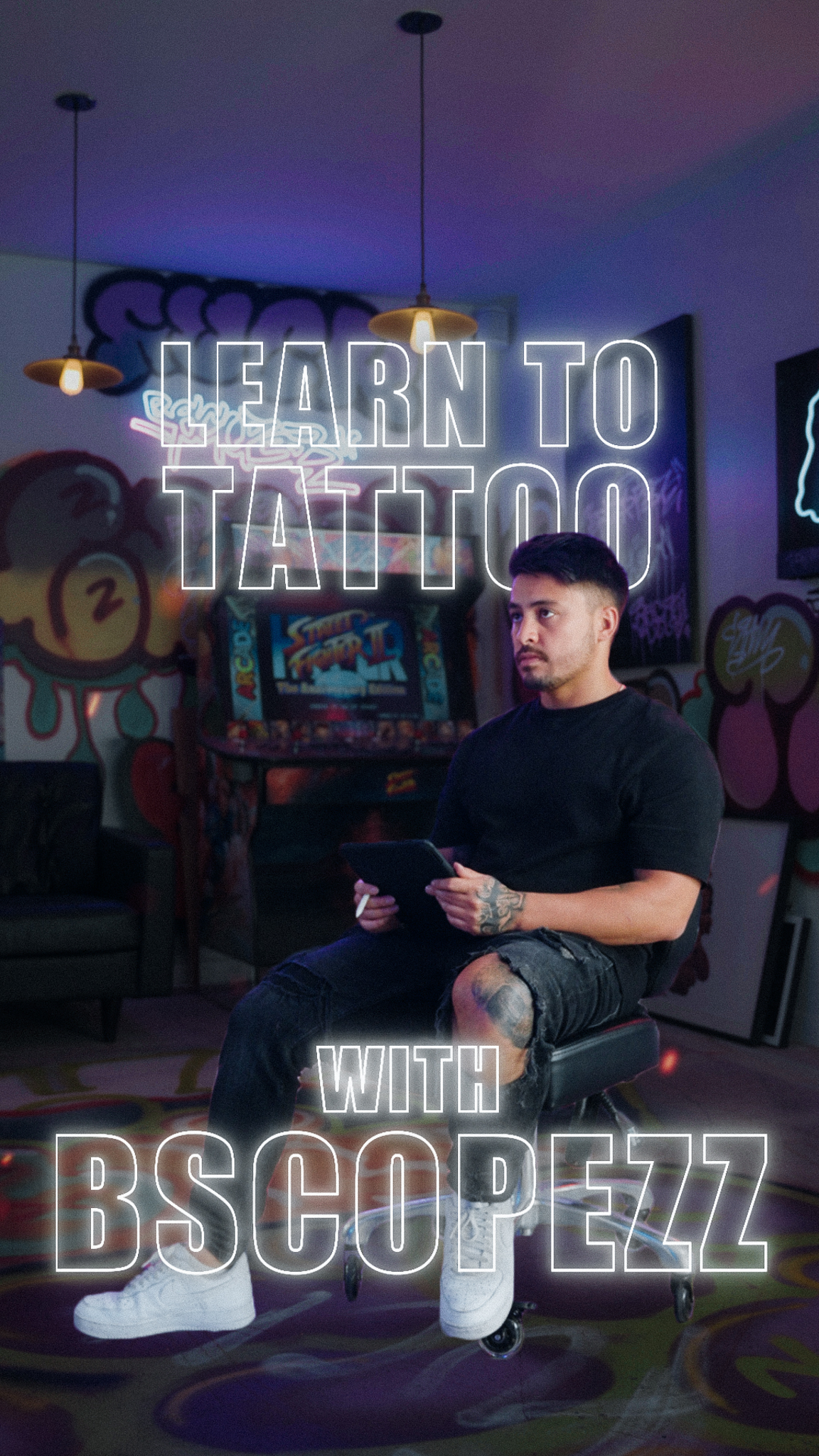 Branden sitting in tattoo chair to teach how to tattoo